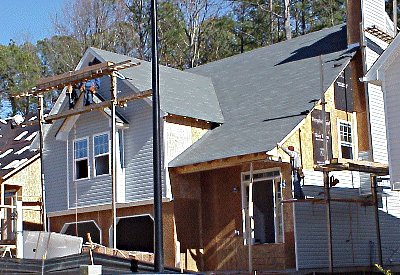 work crew putting siding on house